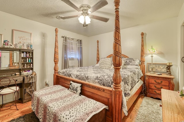 bedroom with ceiling fan, light hardwood / wood-style floors, and a textured ceiling