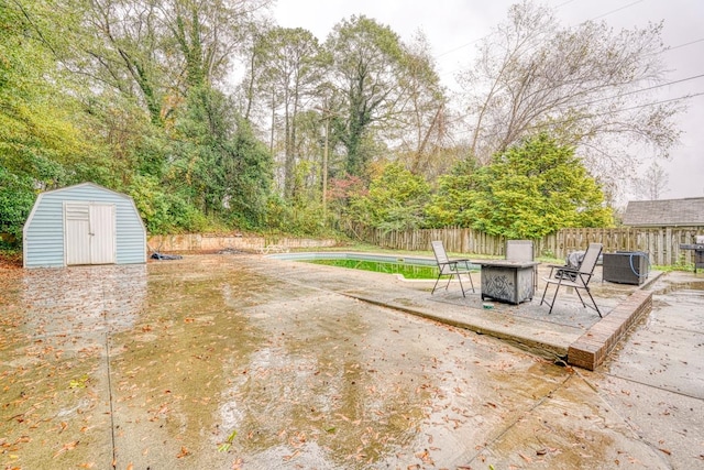 view of yard featuring a storage unit, an outdoor fire pit, a patio area, and central air condition unit