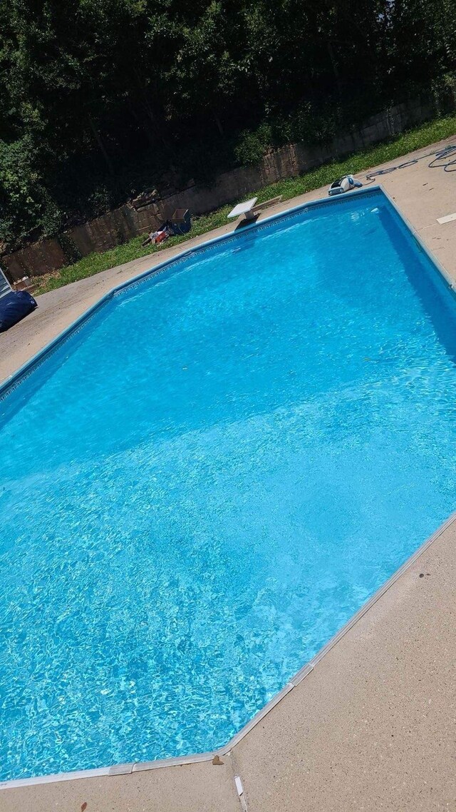 view of swimming pool featuring a diving board