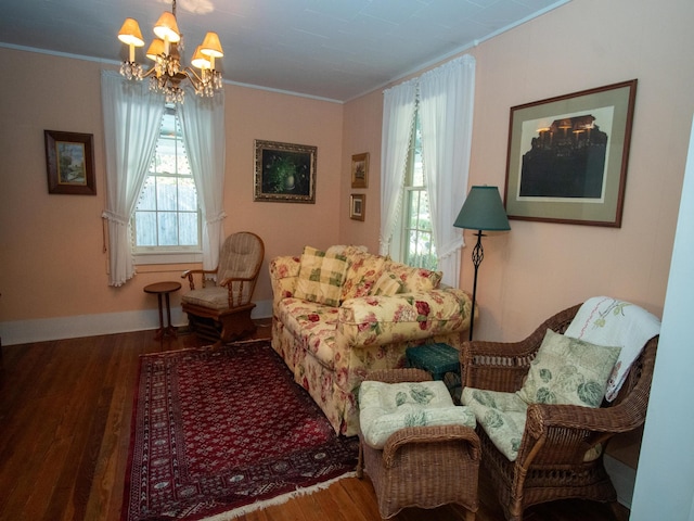 sitting room with hardwood / wood-style flooring, an inviting chandelier, and crown molding