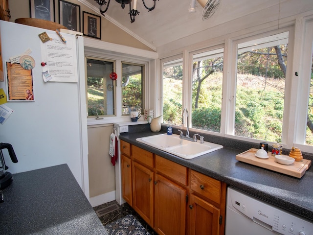 kitchen featuring white appliances, vaulted ceiling, a wealth of natural light, and sink