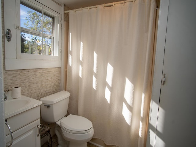 bathroom featuring vanity, toilet, tile walls, and curtained shower