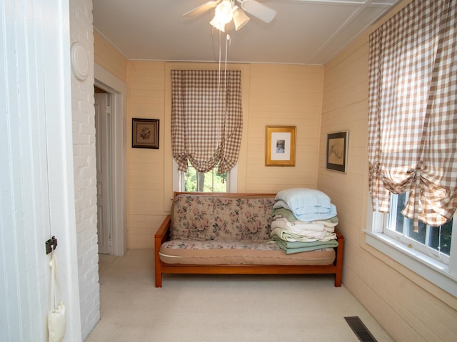 living area with ceiling fan and light colored carpet