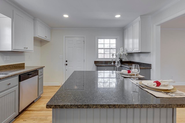 kitchen with light hardwood / wood-style floors, a kitchen island, stainless steel dishwasher, and crown molding