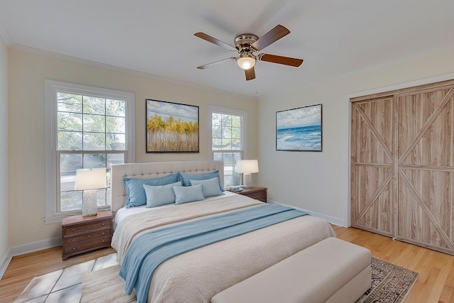 bedroom featuring multiple windows, ceiling fan, and wood-type flooring