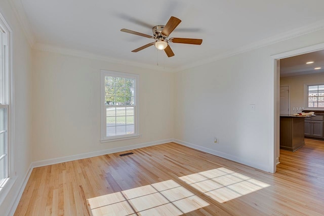 spare room with ceiling fan, ornamental molding, and light wood-type flooring