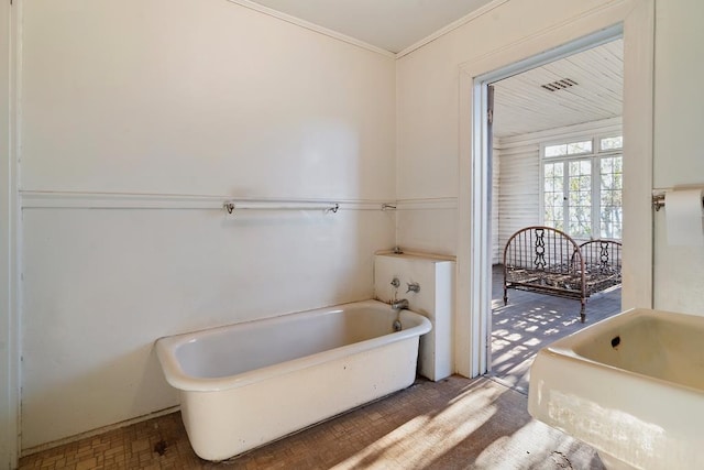 bathroom with a washtub and crown molding