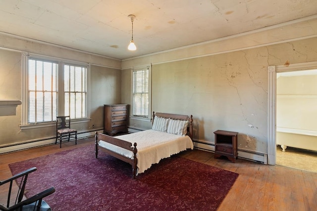 bedroom with hardwood / wood-style floors and a baseboard radiator