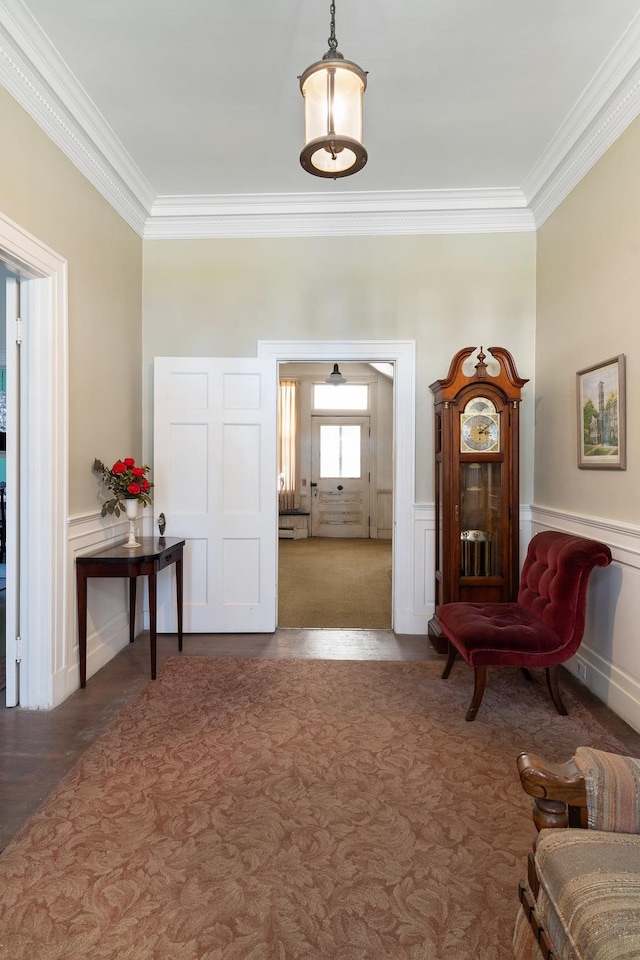 sitting room with ornamental molding and carpet floors