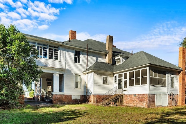 rear view of house with a yard and a sunroom