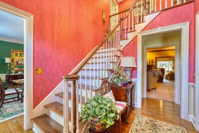 stairway featuring hardwood / wood-style floors and ornamental molding