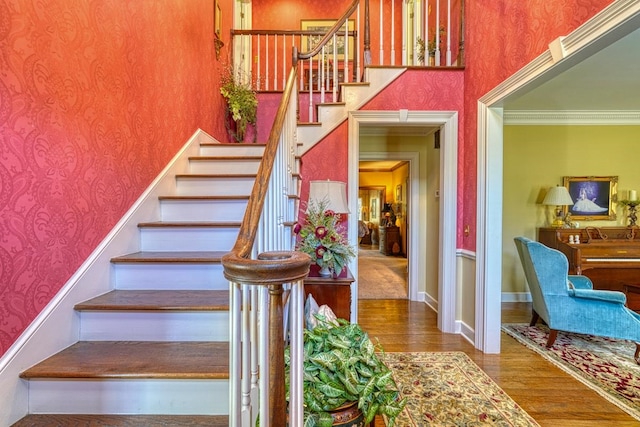 staircase featuring hardwood / wood-style flooring and crown molding