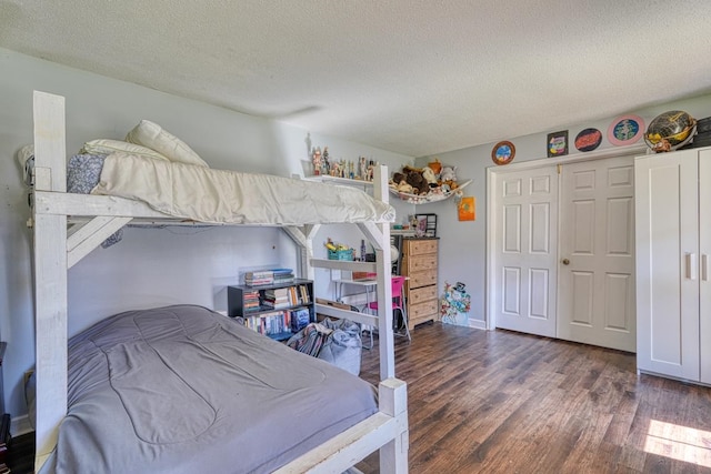 bedroom featuring a closet, a textured ceiling, and wood finished floors