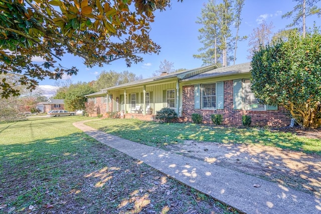 single story home with board and batten siding, covered porch, brick siding, and a front lawn