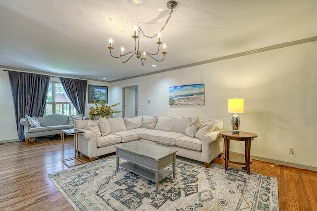 living room featuring a chandelier, wood-type flooring, and ornamental molding