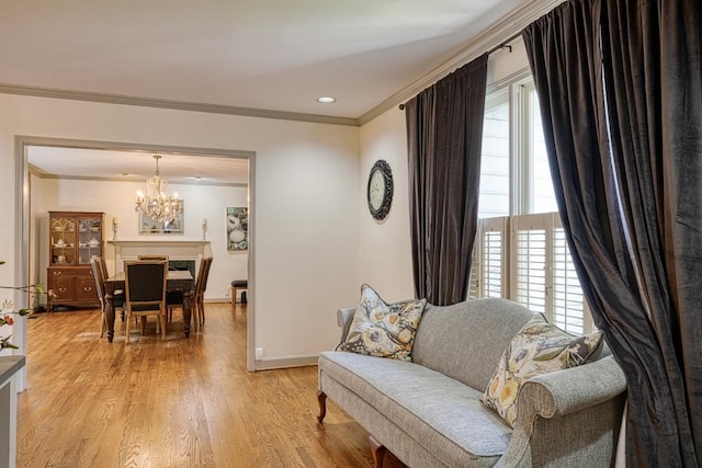 living room featuring a chandelier, ornamental molding, and light wood-type flooring