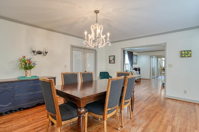 dining space featuring a chandelier, light hardwood / wood-style floors, and ornamental molding