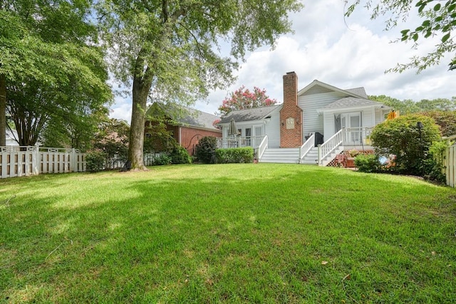 rear view of property featuring a lawn