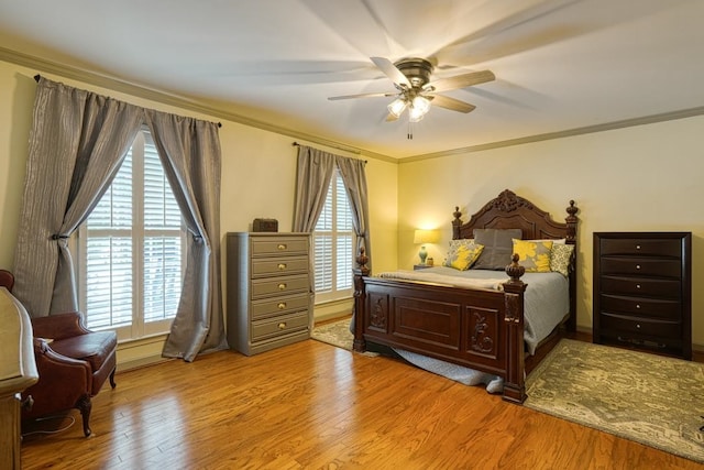 bedroom with multiple windows, ceiling fan, crown molding, and light hardwood / wood-style floors