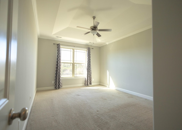 carpeted empty room featuring ceiling fan, crown molding, and a tray ceiling