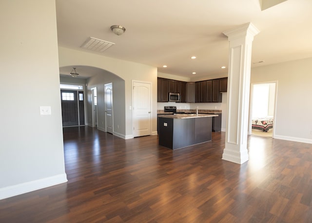 kitchen with dark brown cabinetry, a kitchen island, dark hardwood / wood-style floors, and appliances with stainless steel finishes