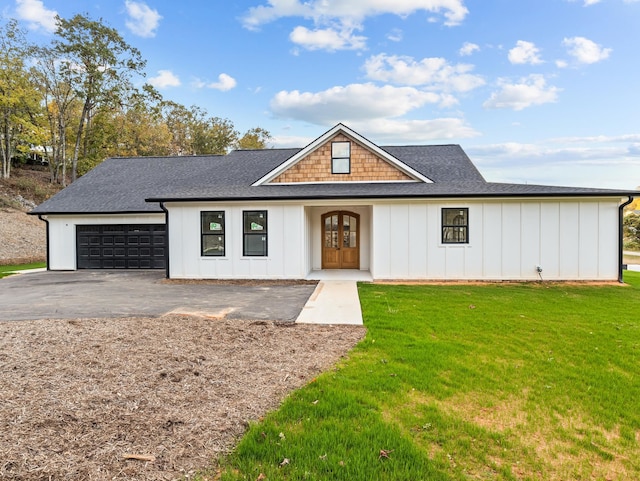 modern farmhouse featuring a garage and a front lawn