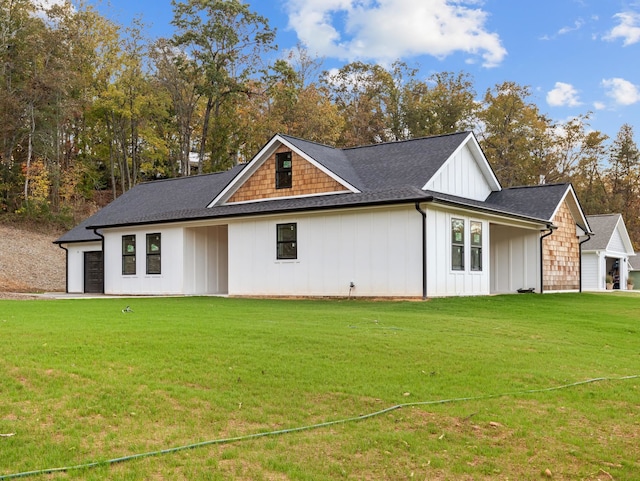 back of property featuring a garage and a yard