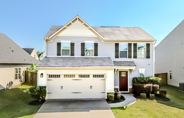 view of front of house with a front lawn, central AC unit, and a garage