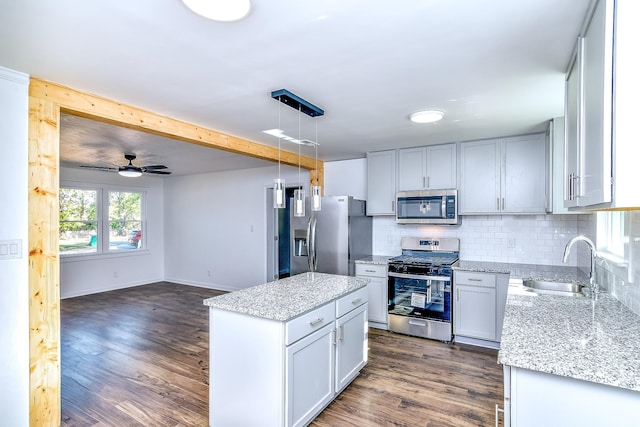 kitchen featuring dark hardwood / wood-style flooring, stainless steel appliances, ceiling fan, sink, and hanging light fixtures