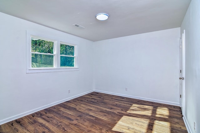 spare room featuring dark wood-type flooring