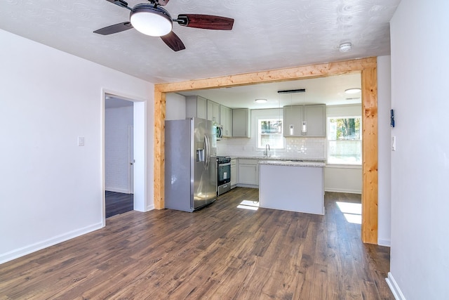 kitchen with dark hardwood / wood-style flooring, tasteful backsplash, a textured ceiling, stainless steel appliances, and sink