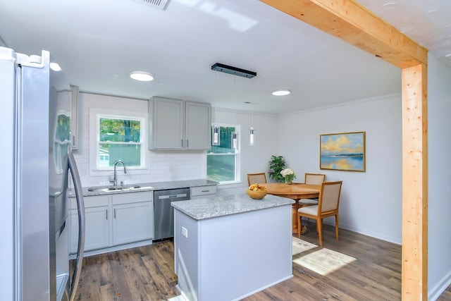 kitchen with stainless steel appliances, tasteful backsplash, dark hardwood / wood-style floors, decorative light fixtures, and a kitchen island