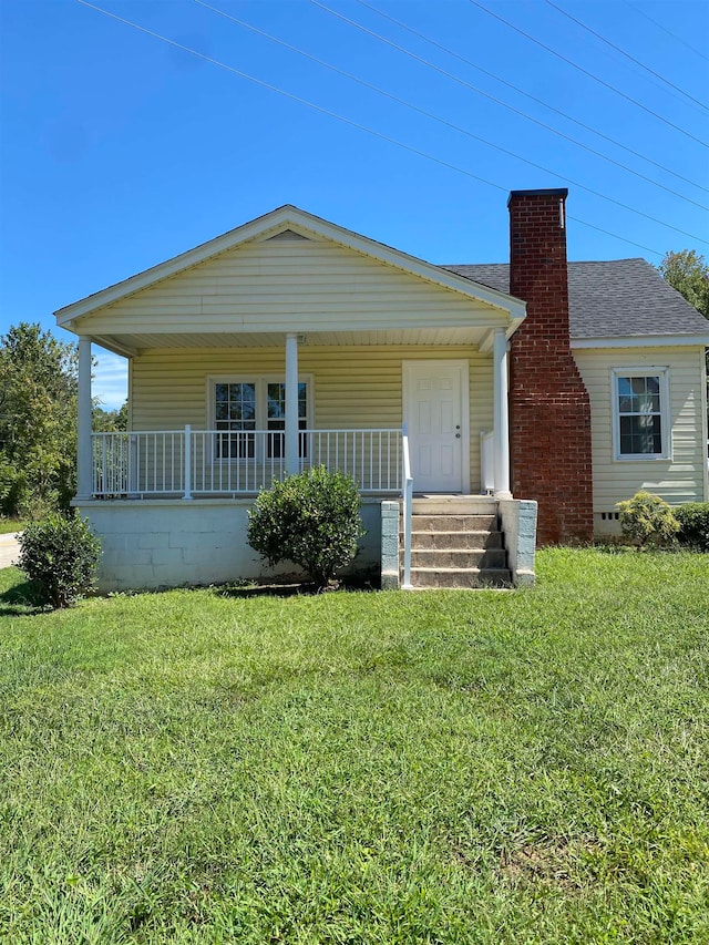 view of front of home with covered porch and a front lawn