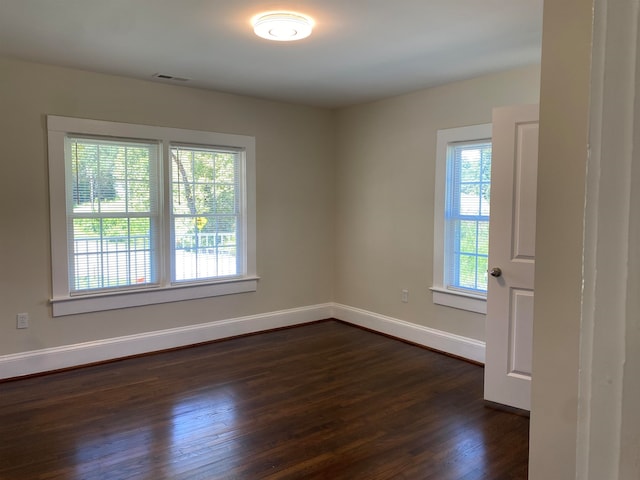 empty room featuring dark hardwood / wood-style floors and a healthy amount of sunlight