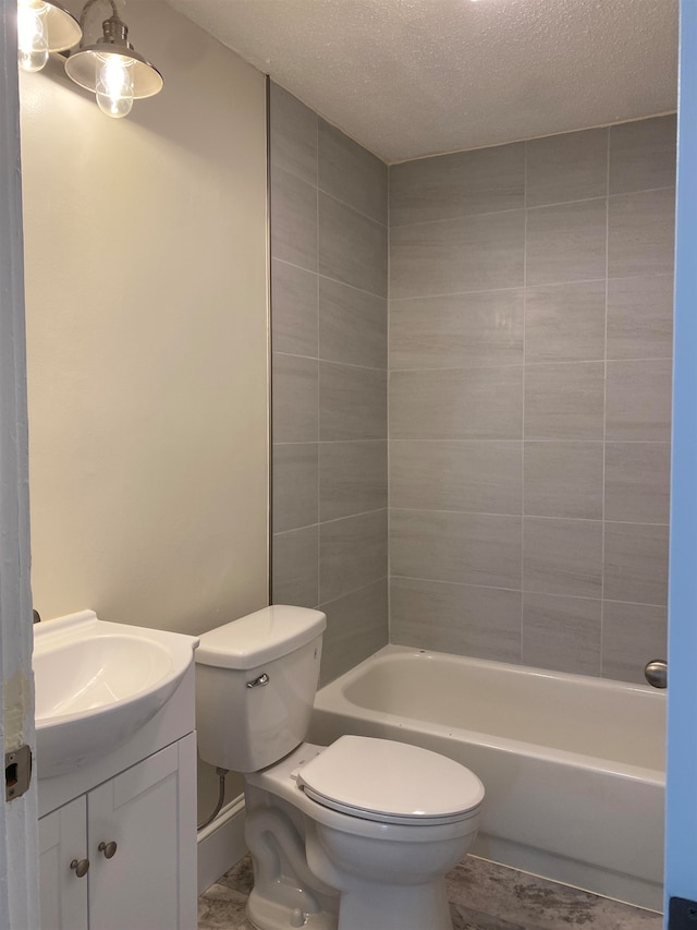 full bathroom with vanity, a textured ceiling, toilet, and tiled shower / bath