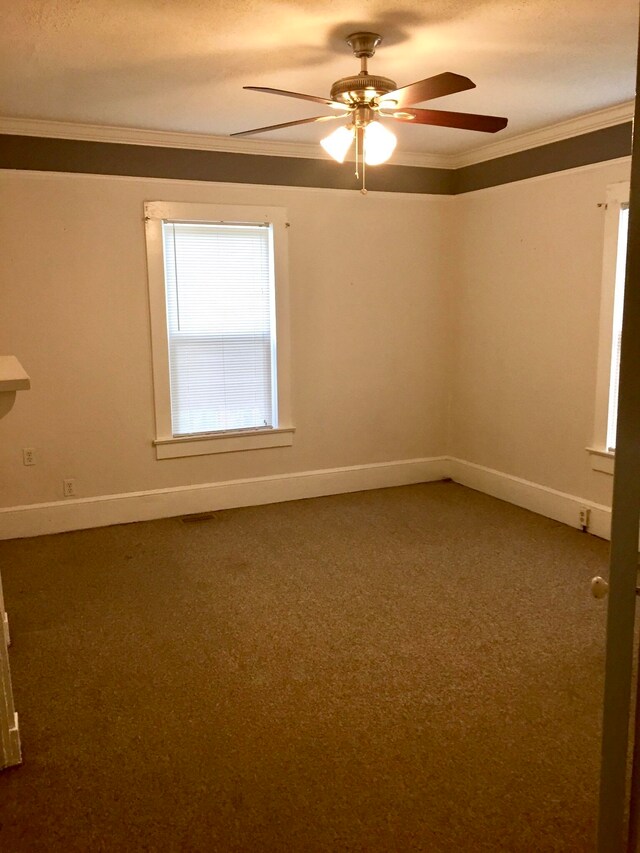 empty room featuring carpet floors, crown molding, ceiling fan, and a textured ceiling