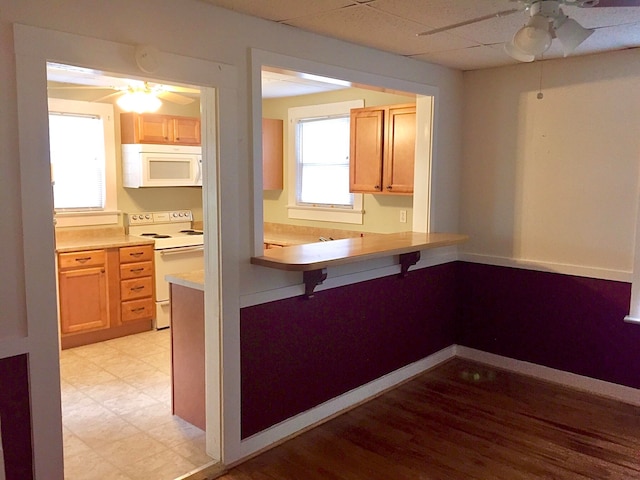 kitchen featuring white appliances, plenty of natural light, and ceiling fan