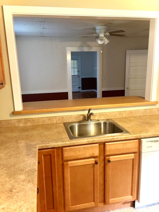 kitchen featuring ceiling fan, sink, and white dishwasher