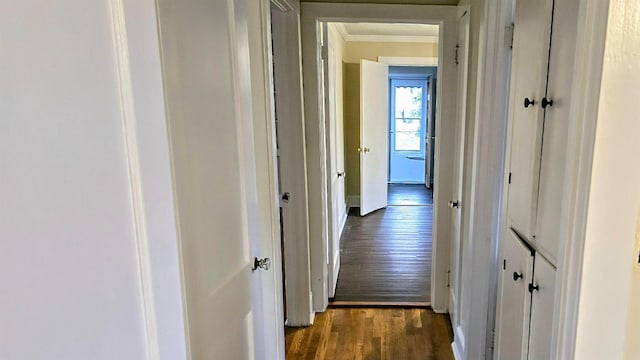 hall with ornamental molding and dark wood-type flooring