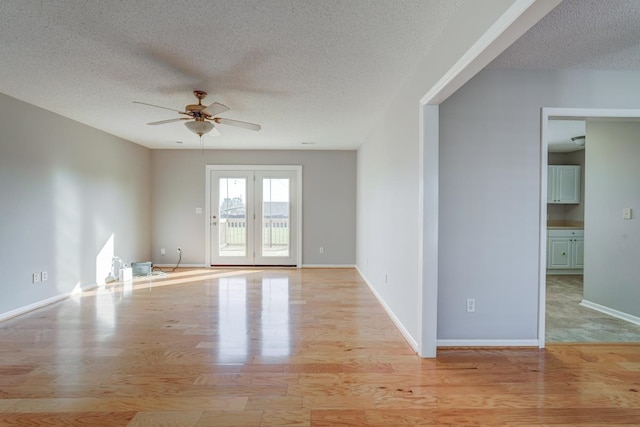 spare room featuring ceiling fan, light hardwood / wood-style floors, and a textured ceiling