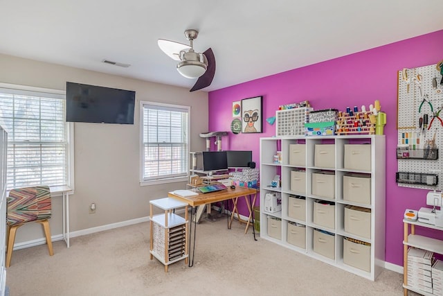 carpeted home office featuring ceiling fan