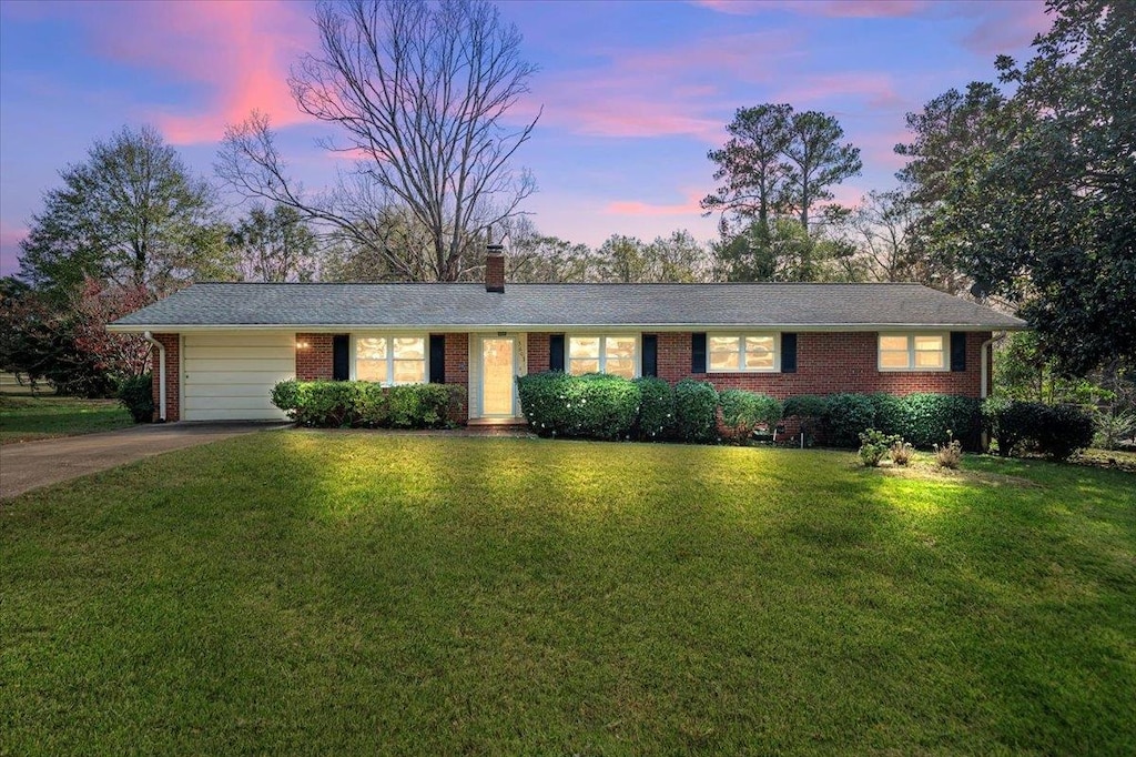 single story home with a yard and a garage