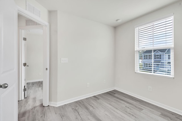 unfurnished room with a healthy amount of sunlight and light hardwood / wood-style floors