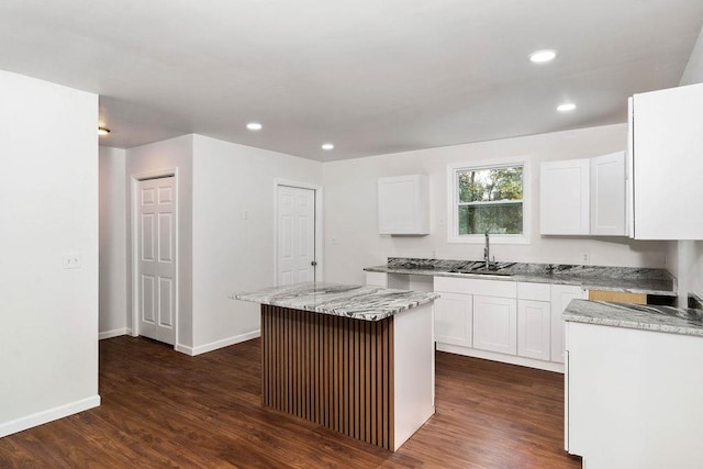 kitchen with white cabinets, a kitchen island, dark hardwood / wood-style flooring, and sink