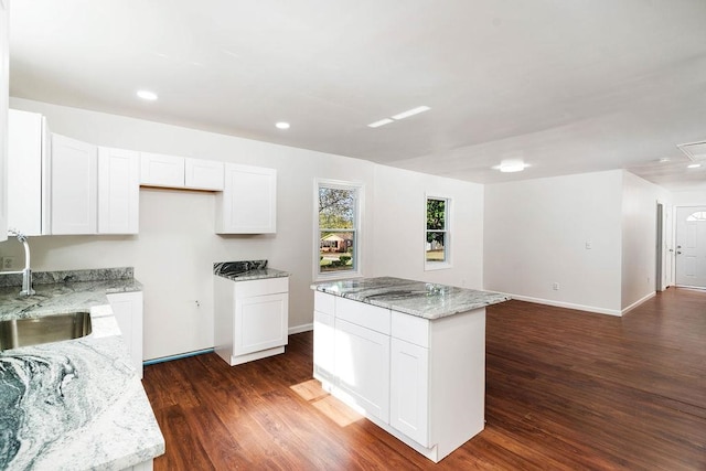 kitchen featuring white cabinets, a kitchen island, dark hardwood / wood-style flooring, and sink