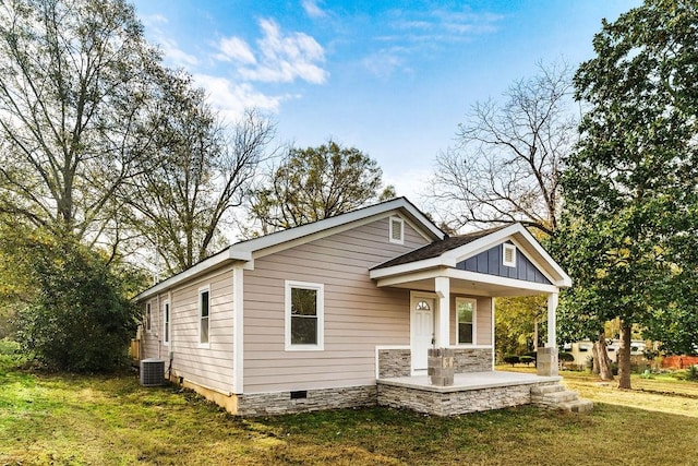 view of front of property featuring a front yard, a porch, and central AC