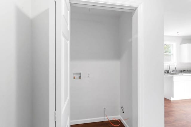 clothes washing area featuring washer hookup, wood-type flooring, and sink