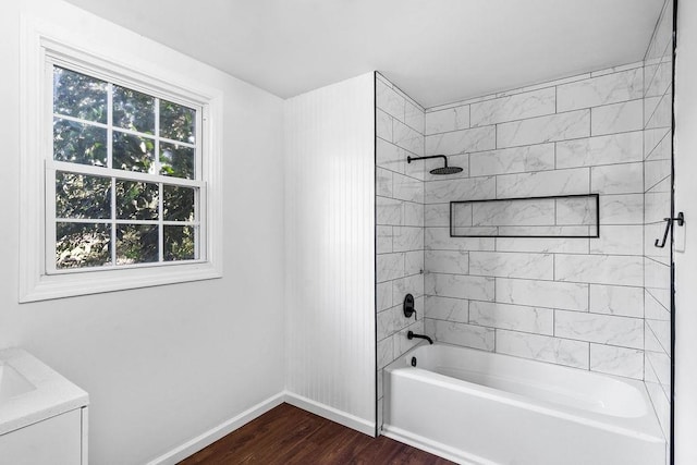 bathroom with tiled shower / bath combo, plenty of natural light, and wood-type flooring