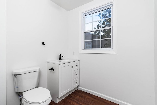 bathroom with wood-type flooring, vanity, and toilet