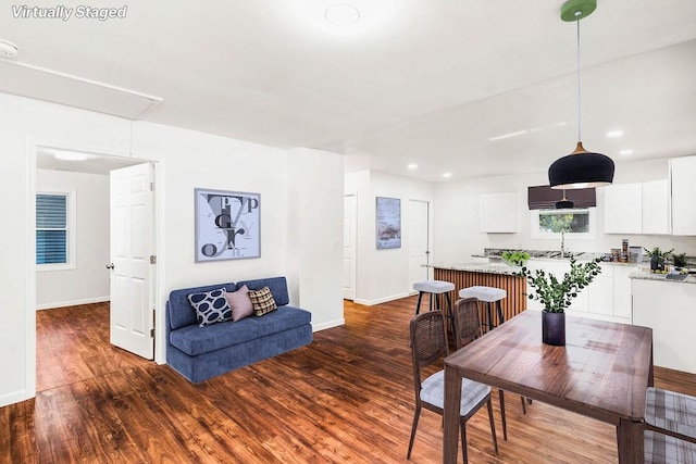 dining space featuring dark wood-type flooring and sink